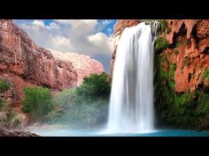 a large waterfall in the middle of a canyon