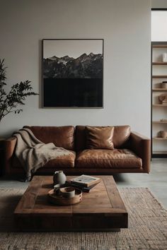 a living room with a brown leather couch and coffee table