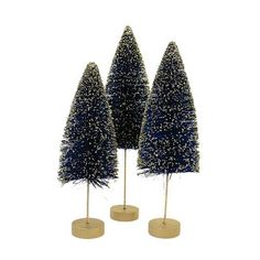 three small christmas trees on wooden bases with blue tinsel and white snow flakes