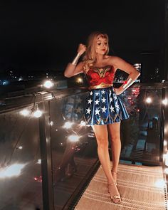 a woman in a wonder costume standing on a balcony