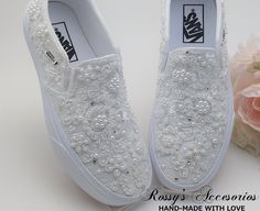 the white shoes are decorated with flowers and pearls