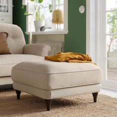 a white ottoman sitting on top of a rug in a living room