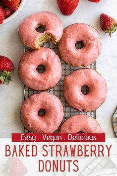 strawberry donuts on a cooling rack with fresh strawberries in the background and text overlay reading easy vegan delicious baked strawberry donuts