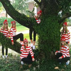 a group of women in matching red and white outfits posing for a photo under a tree