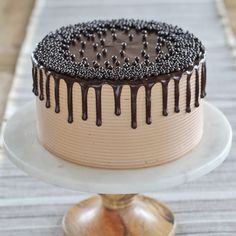 a cake with chocolate icing and sprinkles sitting on top of a white plate