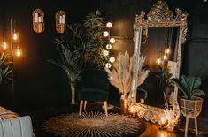 an ornate mirror in the corner of a room with candles and plants on the floor