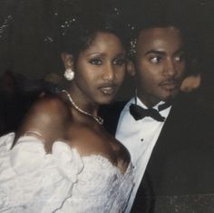 a man and woman in formal wear posing for a photo at their wedding reception,