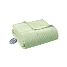 a green blanket and remote control on a white surface