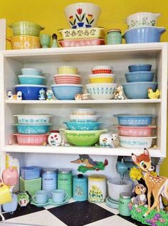 a shelf filled with lots of colorful dishes and bowls on top of eachother