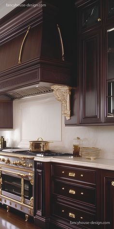 a kitchen with wooden cabinets and gold trimmings on the stove top, oven hood, and counter tops