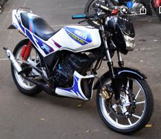 a white and blue motorcycle parked in a parking lot