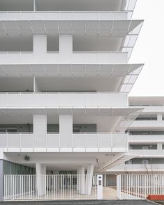 an empty parking lot in front of a building with balconies on the sides