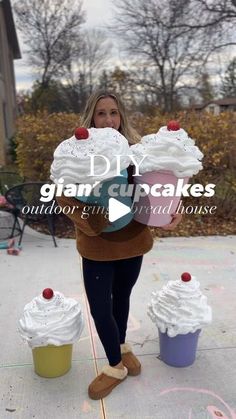 a woman standing on the sidewalk with cupcakes in front of her