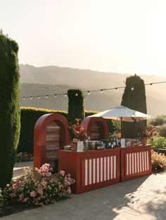 an outdoor bar set up with flowers and lights