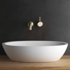 a white bowl sink sitting on top of a wooden counter next to a faucet