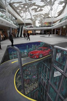 the reflection of a red car is shown in an upside down building's parking lot