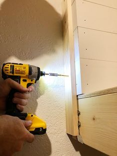 a person using a screwdriver to drill holes in the wall