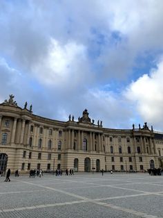 people are walking around in front of a large building