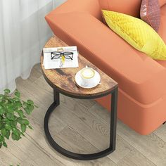 a coffee table with glasses on it next to an orange couch and potted plant