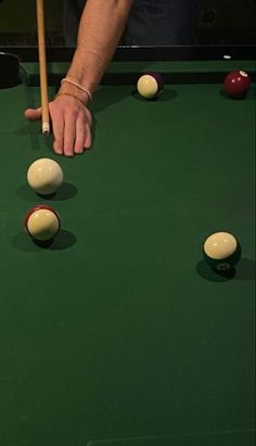 a man is about to hit the ball with his cues on a pool table