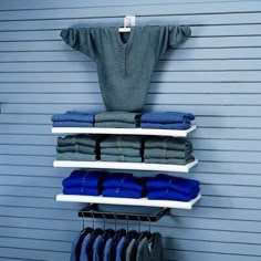 clothes are hanging on shelves in front of a garage door