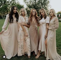 four women in long dresses posing for a photo