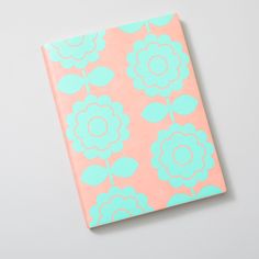 a pink and blue notebook with flowers on it