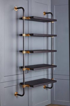 the shelf is made out of wood and has two brass handles on each side, along with three black shelves