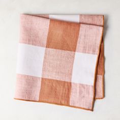 two orange and white checkered napkins sitting on top of each other