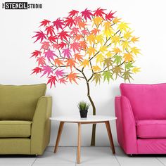 a living room with two couches and a colorful tree wall decal on the wall