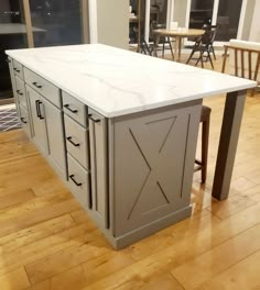 a kitchen island with an open door on the front and side, in a room with hardwood floors