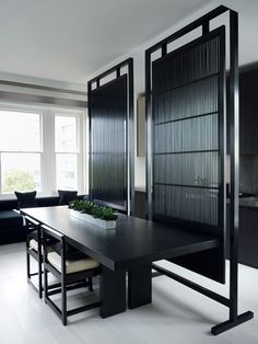 a dining room with black furniture and white tile flooring