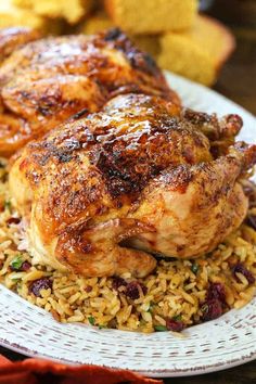 chicken and rice on a white plate with bread in the backgroung area