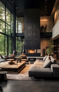 a living room filled with lots of furniture next to tall glass windows on the wall