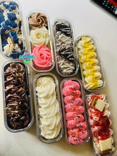 an assortment of different types of desserts in plastic containers on a white counter top