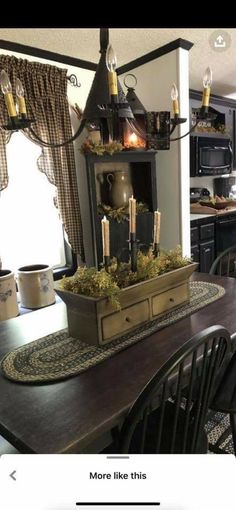 a dining room table with candles on top of it and other decorations in the background