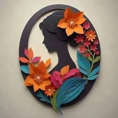 a woman's profile with flowers and leaves in the shape of a circular frame