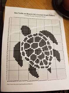 a cross stitch turtle pattern on top of a table