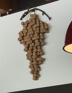 a bunch of wine corks hanging from the side of a wall next to a lamp