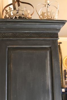 an old black cabinet with crown on top