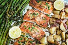 salmon, potatoes and asparagus on a baking sheet with lemon wedges for garnish