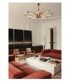 a living room filled with furniture and a chandelier hanging from it's ceiling