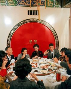 a group of people sitting around a table with plates of food in front of them