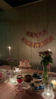 a table with cake, candles and flowers on it