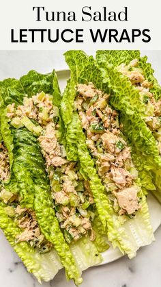 lettuce wraps filled with tuna salad on top of a white plate next to a fork