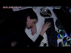 a woman laying her head on a keyboard next to cd's and other items