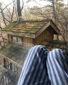 a person laying down with their feet up in front of a bird house