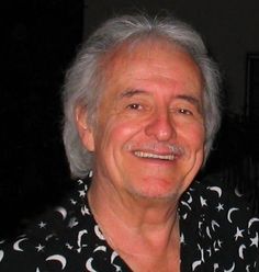 an older man wearing a black and white shirt with stars and moon designs on it