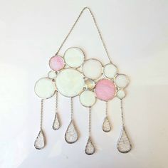 a white and pink necklace hanging from a chain