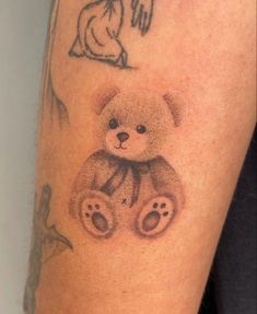 a tattoo on the arm of a person with a teddy bear